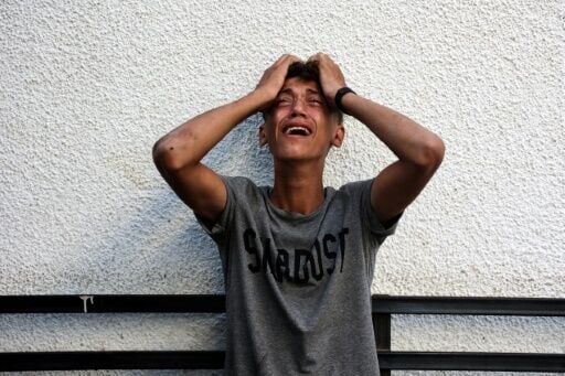 A Palestinian youth reacts to seeing the bodies of his relatives after an Israeli strike in Jabalia