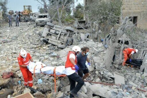 Lebanese Red Cross paramedics transport a body unearthed from the rubble at the site of an Israeli air strike that targeted Aito village in a Christian-majority area far from Hezbollah strongholds