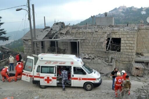 Paramedics with the Lebanese Red Cross transport a body unearthed from the rubble into an ambulance at the site of an Israeli airstrike that targeted the northern Lebanese village of Aito on October 14, 2024