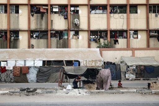 A Palestinian man bakes bread at a makeshift displacement camp in central Gaza