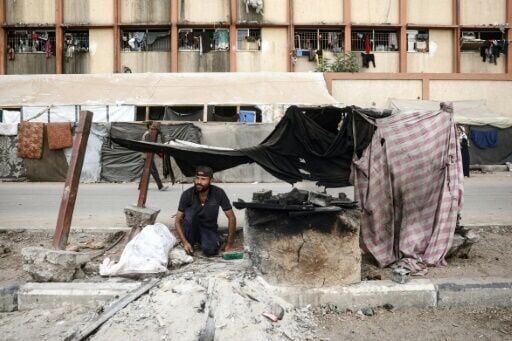 A Palestinian man bakes bread at a makeshift displacement camp in the central Gaza Strip