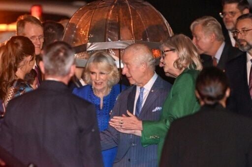 Britain's King Charles III (centre R) and Queen Camilla (centre L) are greeted upon their arrival at Sydney International Airport on Friday night
